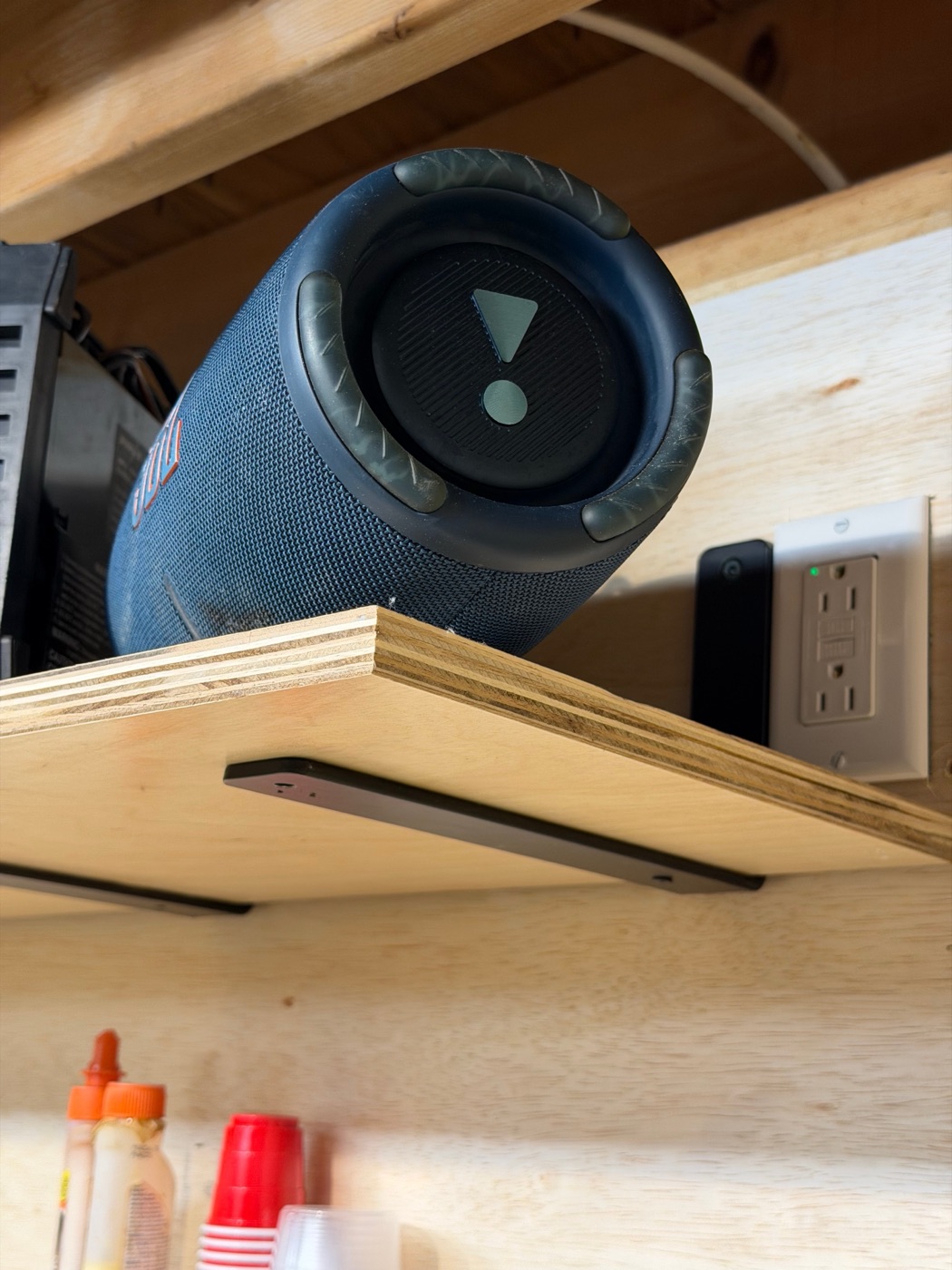 Bluetooth speaker on shelf near outlet